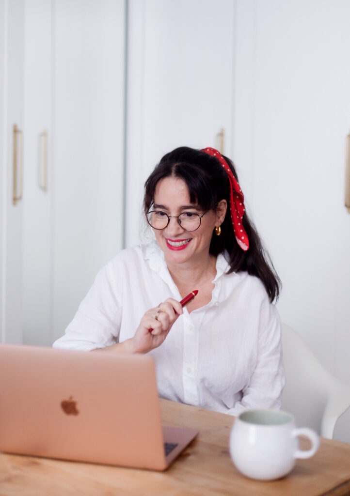 Sabine Haag, Expertin für Ordnung, sitzt an Ihrem Notebook.